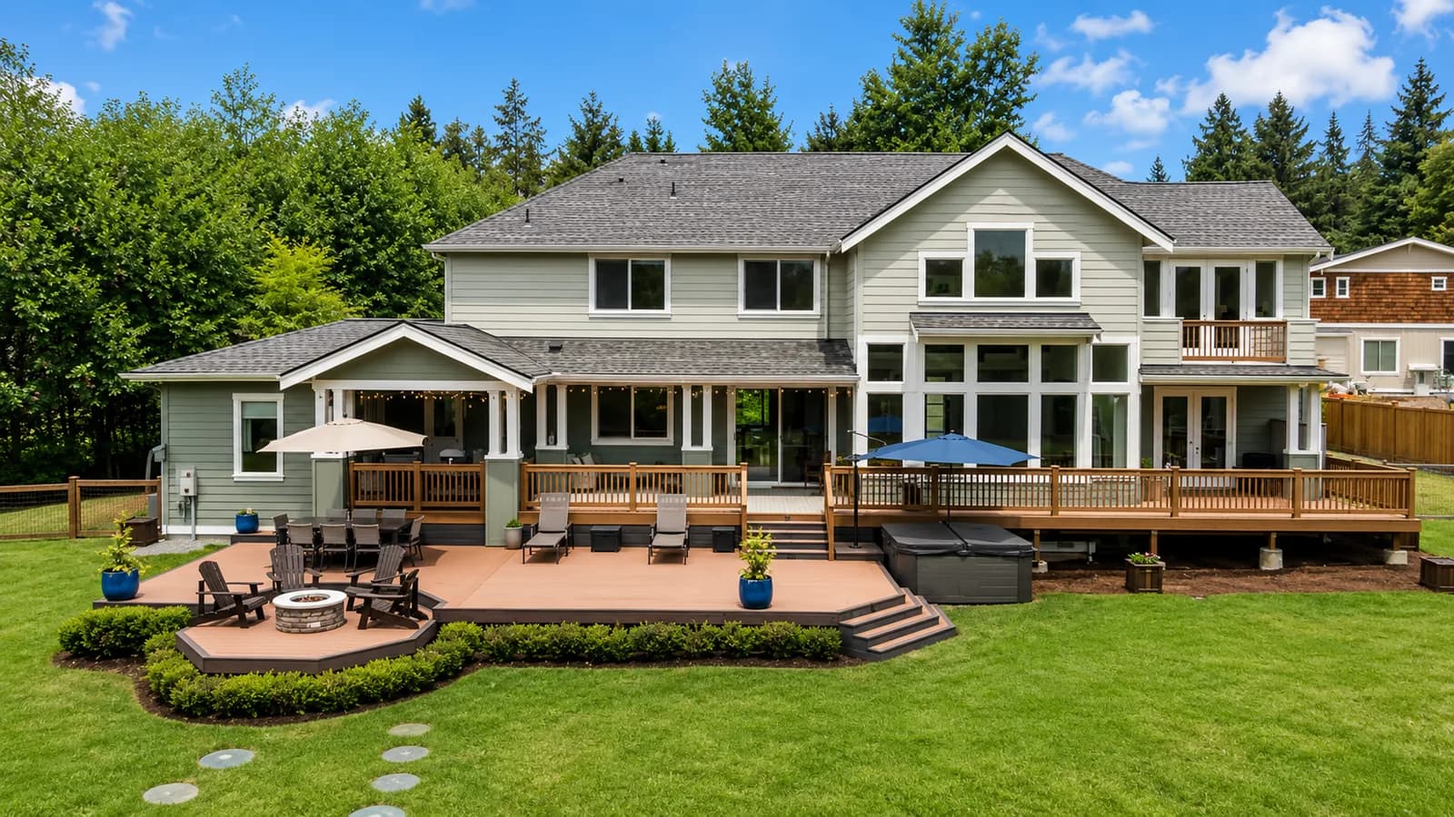 Large multi-level composite deck with a hot tub and fire pit on a Snohomish County home